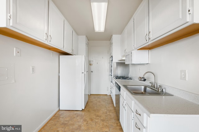 kitchen featuring light countertops, appliances with stainless steel finishes, a sink, and white cabinetry