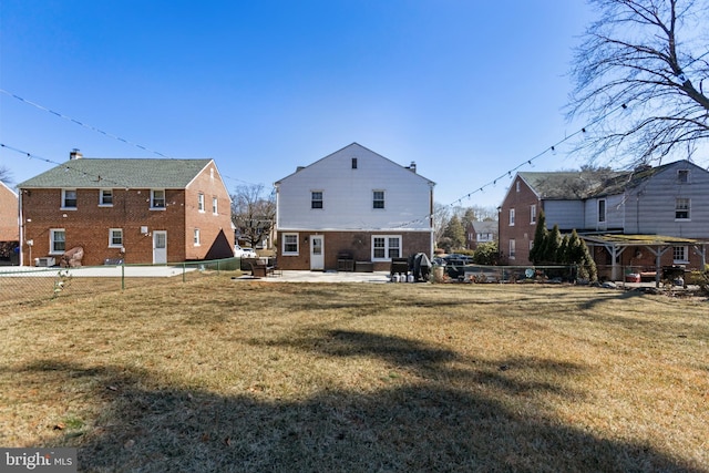 rear view of house with a yard, a patio area, and a fenced backyard