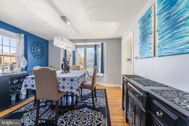 dining area featuring light wood-style floors and baseboards