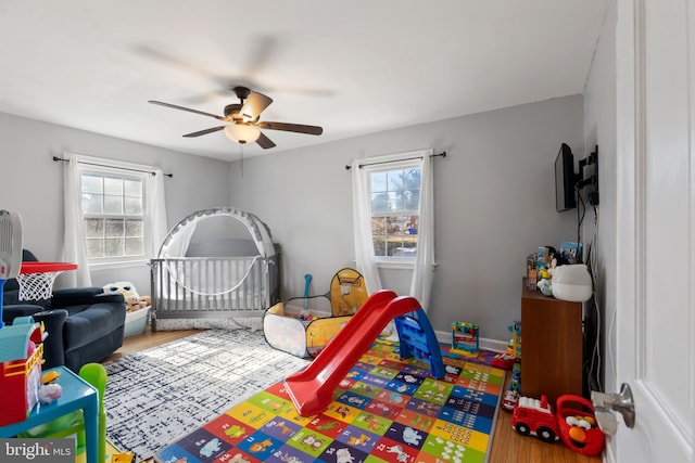 bedroom featuring a ceiling fan, baseboards, and wood finished floors