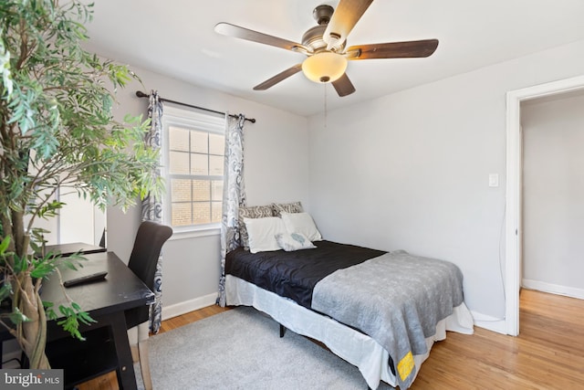 bedroom featuring light wood-style flooring, baseboards, and a ceiling fan