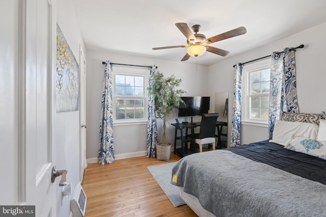 bedroom featuring baseboards, visible vents, a ceiling fan, and light wood-style floors