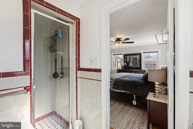 full bath featuring a stall shower, ensuite bath, ceiling fan, and tile walls