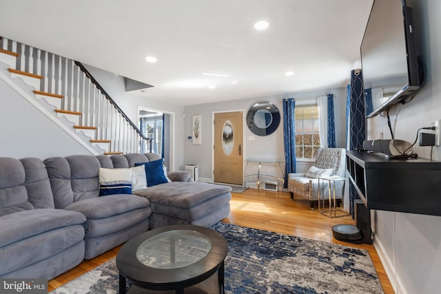 living area with recessed lighting, light wood-style flooring, and stairs