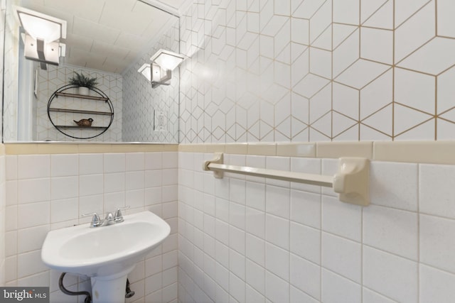 bathroom featuring a sink and tile walls