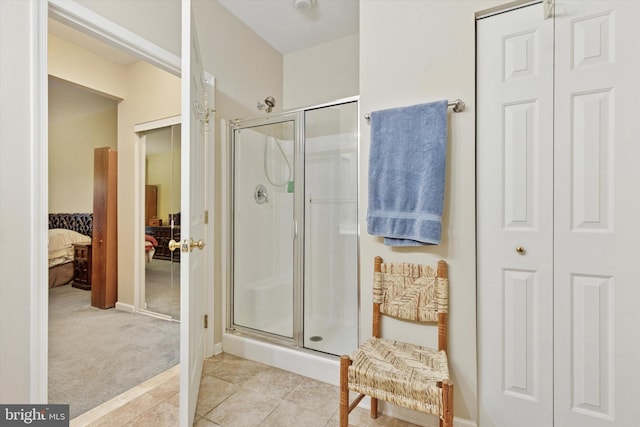 ensuite bathroom with a closet, tile patterned floors, ensuite bath, and a shower stall