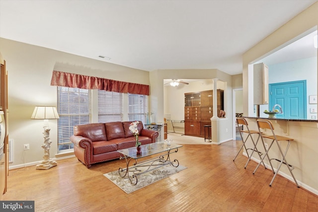 living area featuring visible vents, ceiling fan, baseboards, and wood finished floors