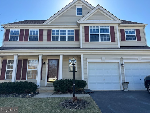 view of front of home with a garage, covered porch, and driveway