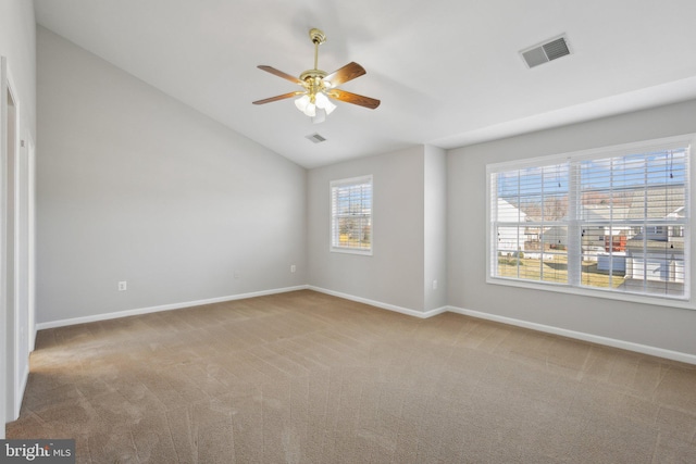 spare room featuring visible vents, carpet floors, baseboards, and vaulted ceiling