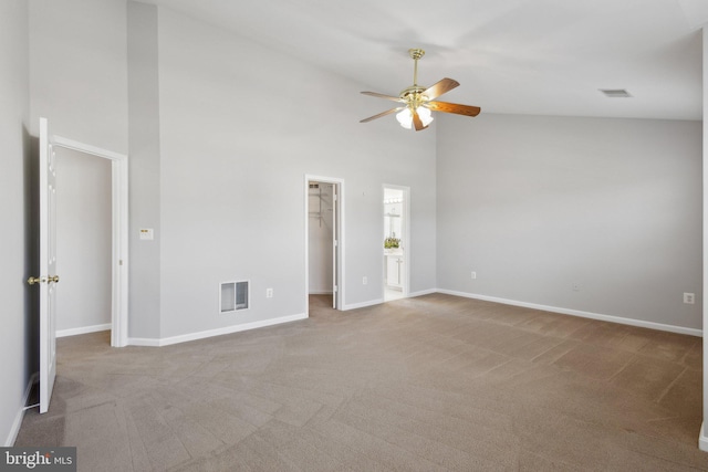 interior space with carpet, baseboards, visible vents, high vaulted ceiling, and a spacious closet