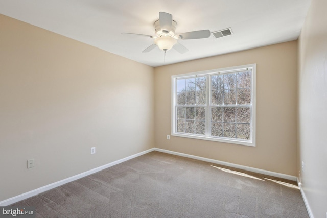 carpeted spare room featuring visible vents, ceiling fan, and baseboards