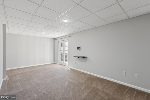 carpeted spare room featuring french doors, a paneled ceiling, and baseboards