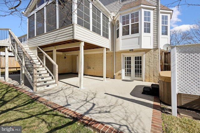 back of property featuring french doors, a patio, a hot tub, and a sunroom