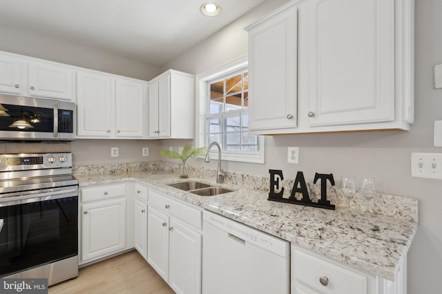 kitchen featuring white cabinets, stainless steel appliances, and a sink