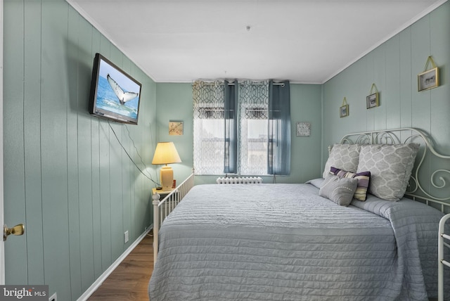 bedroom with dark wood-type flooring, crown molding, and baseboards