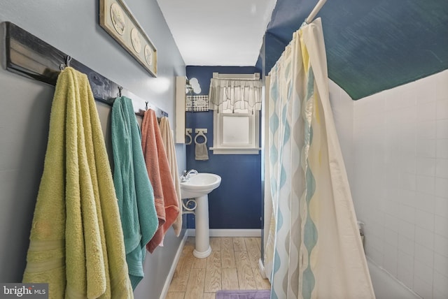 bathroom featuring a sink, baseboards, and wood finished floors