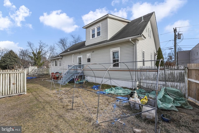 back of house featuring fence and stairs