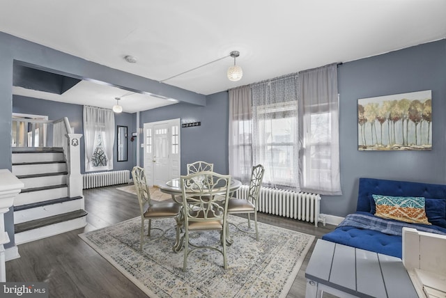 dining area with radiator heating unit, stairs, baseboards, and dark wood-type flooring