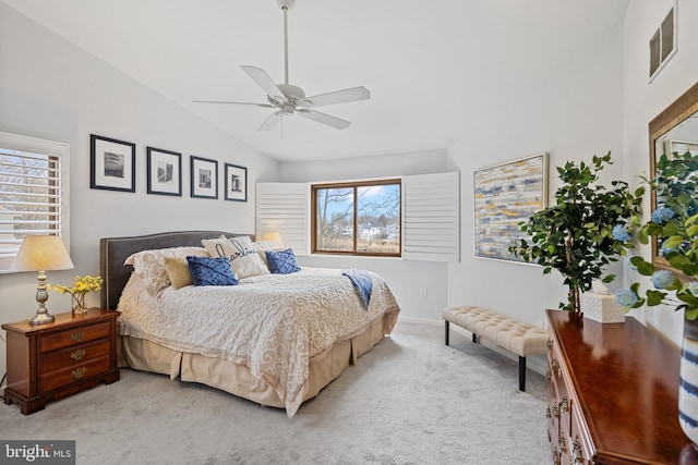 bedroom with visible vents, vaulted ceiling, a ceiling fan, and light colored carpet