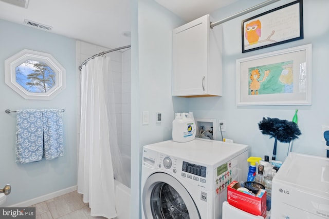 washroom featuring cabinet space, baseboards, visible vents, and washing machine and clothes dryer