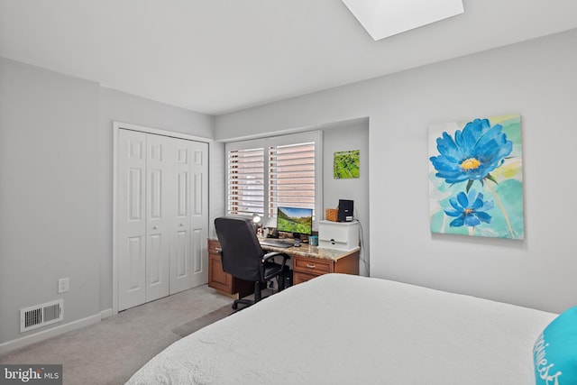 bedroom featuring light carpet, a skylight, baseboards, visible vents, and a closet