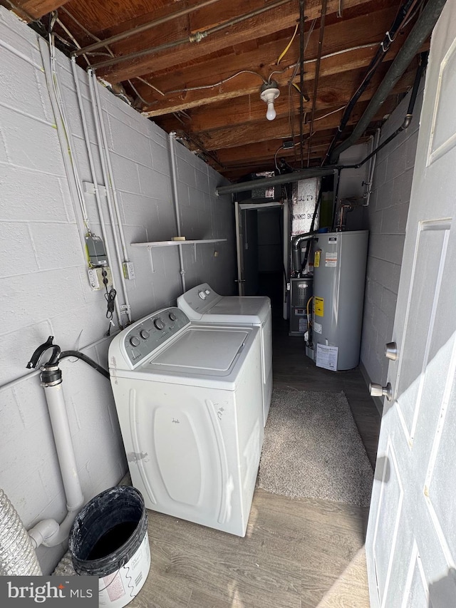 laundry area with washing machine and dryer, water heater, laundry area, wood finished floors, and heating unit