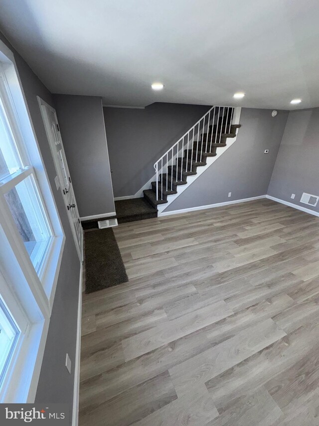 foyer featuring stairway, wood finished floors, visible vents, baseboards, and recessed lighting