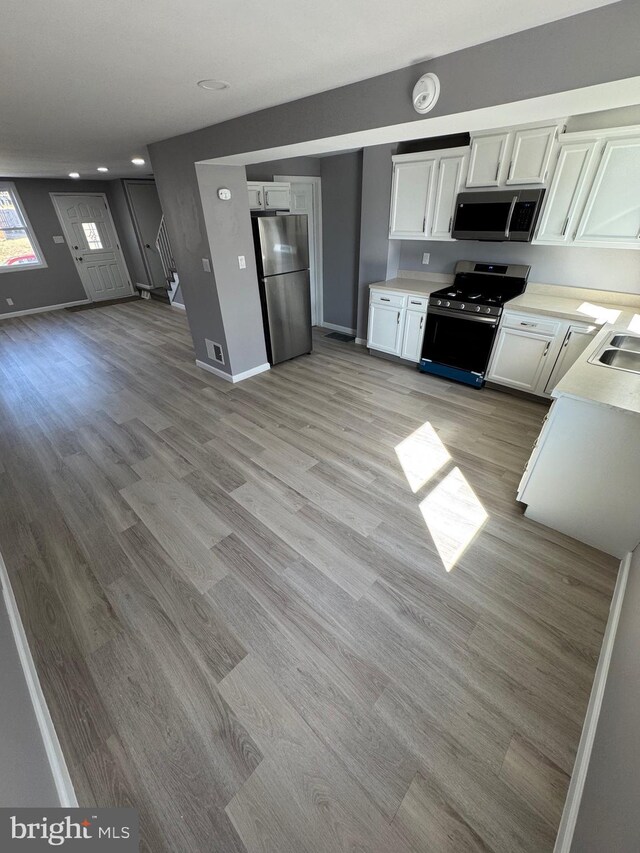 kitchen featuring white cabinetry, light countertops, light wood-style floors, and appliances with stainless steel finishes
