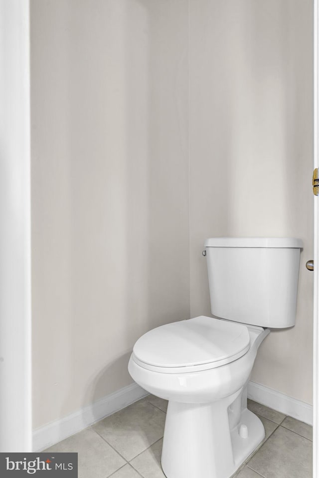 bathroom featuring toilet, baseboards, and tile patterned floors