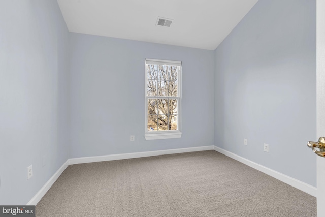 empty room featuring carpet, visible vents, and baseboards