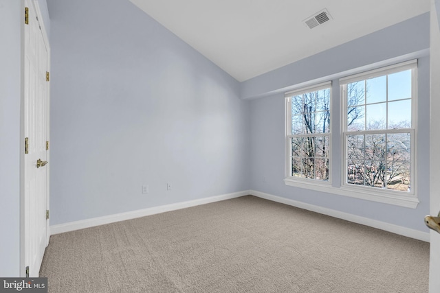 unfurnished room featuring lofted ceiling, a healthy amount of sunlight, visible vents, and carpet flooring