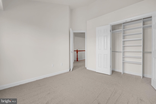 unfurnished bedroom featuring carpet floors, baseboards, and a closet