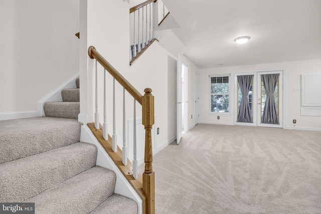 stairway featuring baseboards and carpet flooring