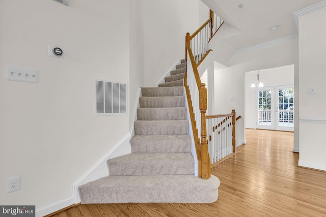 stairs with french doors, visible vents, baseboards, and wood finished floors