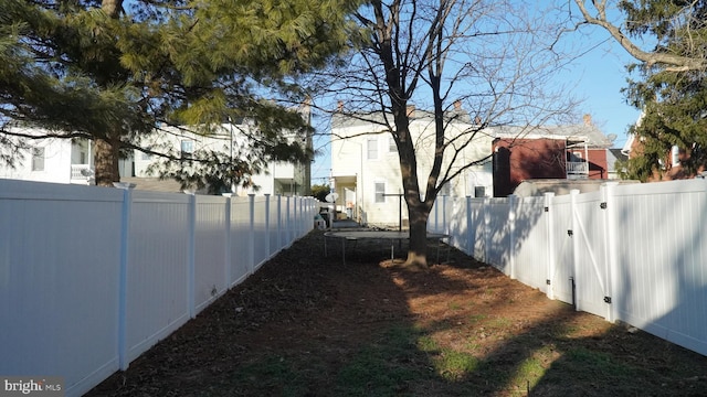 view of yard with a fenced backyard and a gate