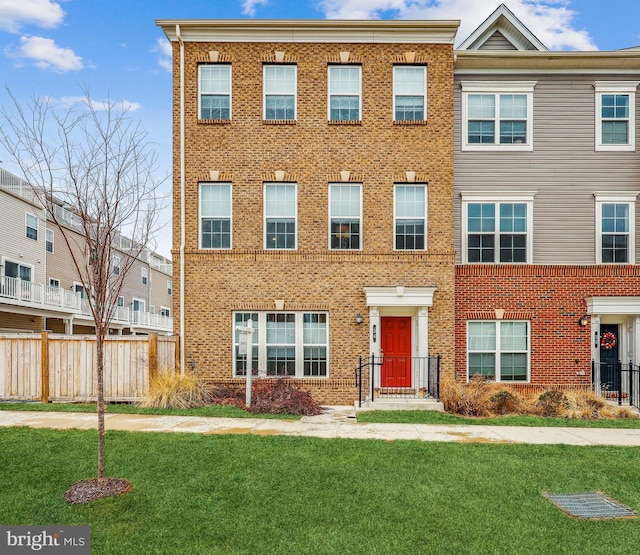 multi unit property with brick siding and a front lawn