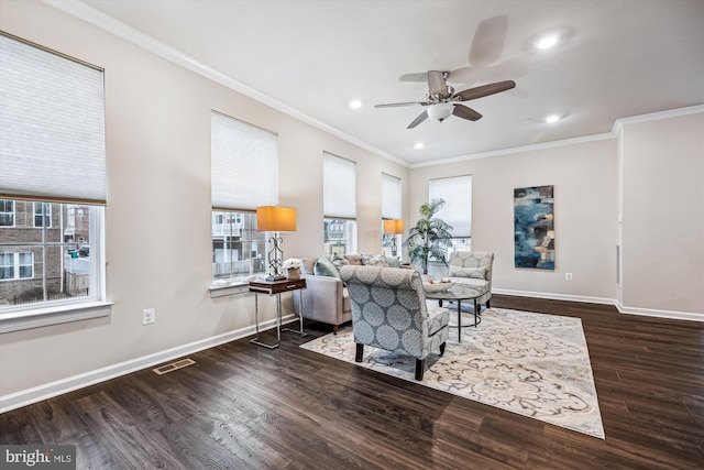 living room with ornamental molding, a healthy amount of sunlight, visible vents, and wood finished floors