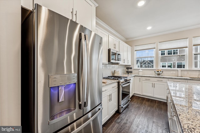 kitchen featuring white cabinetry, appliances with stainless steel finishes, backsplash, and ornamental molding