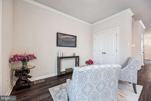 bedroom with dark wood finished floors, visible vents, crown molding, and baseboards