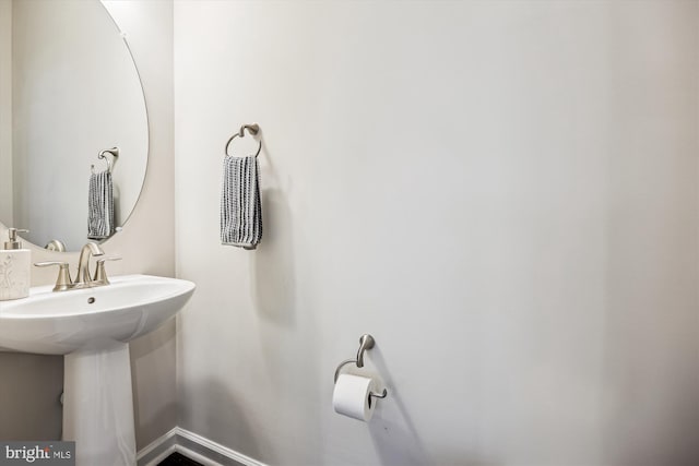 bathroom featuring baseboards and a sink