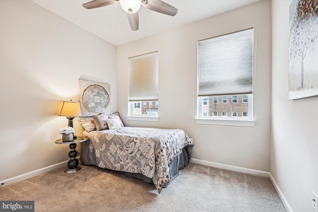 carpeted bedroom with ceiling fan and baseboards