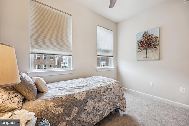 bedroom with carpet, multiple windows, and baseboards