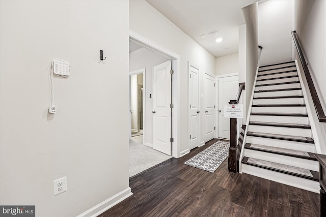 foyer entrance with baseboards, stairway, and wood finished floors