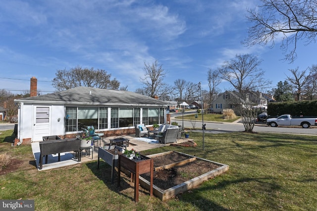 back of property with a patio, outdoor lounge area, a yard, and a garden