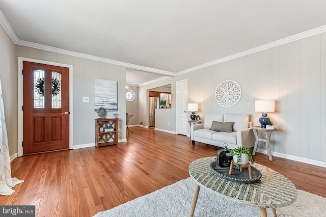 living area with crown molding, baseboards, and wood finished floors