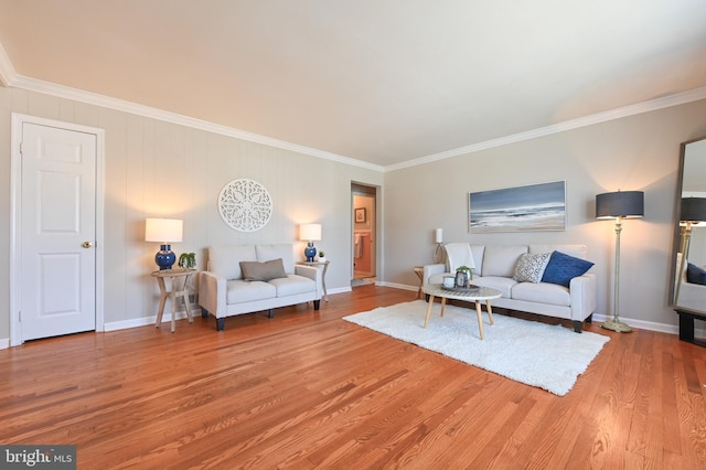 living room featuring crown molding, baseboards, and wood finished floors