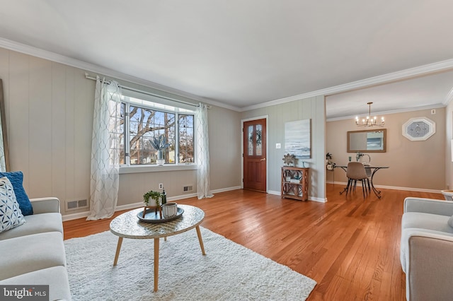 living room featuring visible vents, wood finished floors, and crown molding