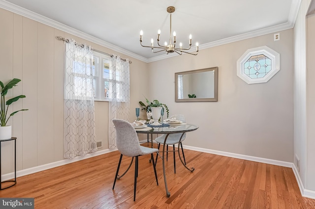 dining area featuring baseboards, an inviting chandelier, wood finished floors, and crown molding