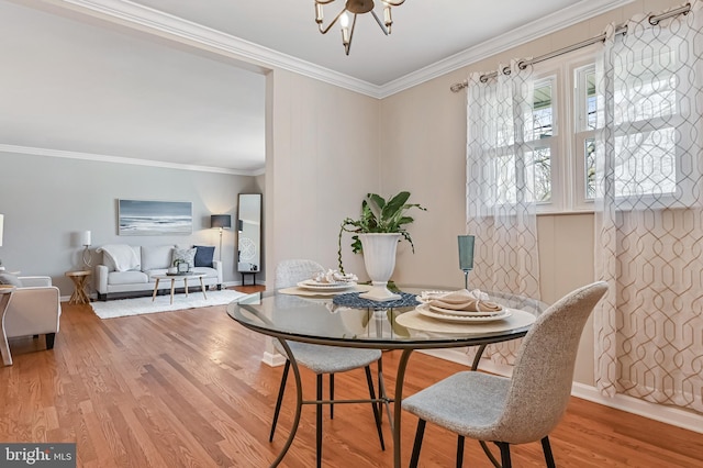 dining space with a chandelier, baseboards, wood finished floors, and ornamental molding