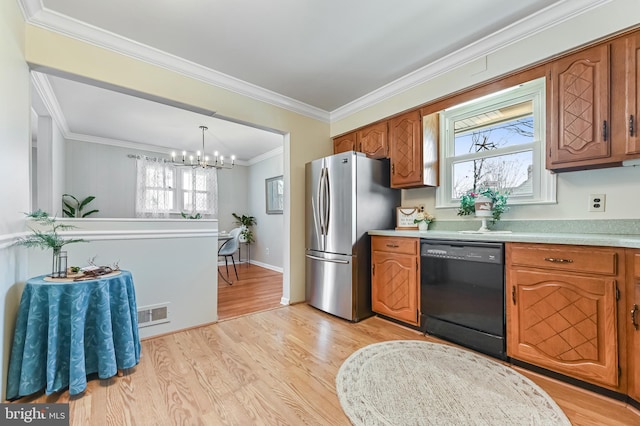 kitchen with light wood-type flooring, dishwasher, brown cabinetry, and freestanding refrigerator